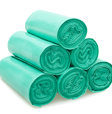 Stacked rolls of green LDPE trash or compost bags